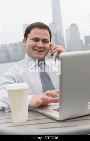 Geschäftsmann mit Laptop im Freien, Jersey City, New Jersey, USA Stockfoto