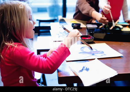 Drei junge Geschwister malen am Tisch Stockfoto