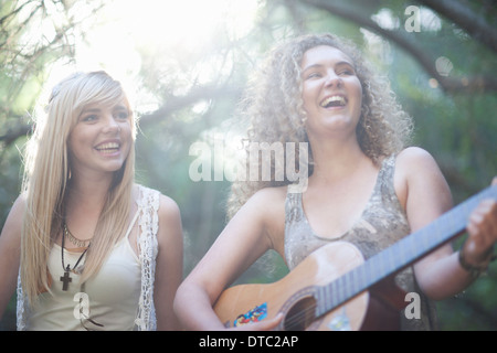 Zwei Mädchen im Teenageralter Gitarre im Wald Stockfoto