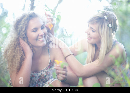 Zwei Mädchen im Teenageralter mit Wildblumen in Wald Stockfoto