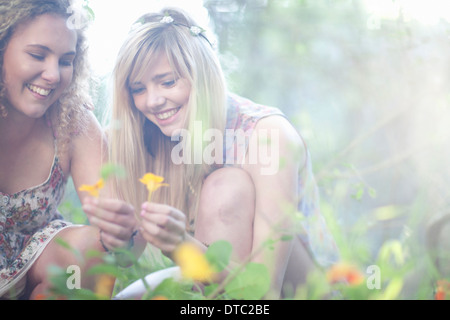 Zwei Mädchen im Teenageralter Kommissionierung Wildblumen in Wald Stockfoto