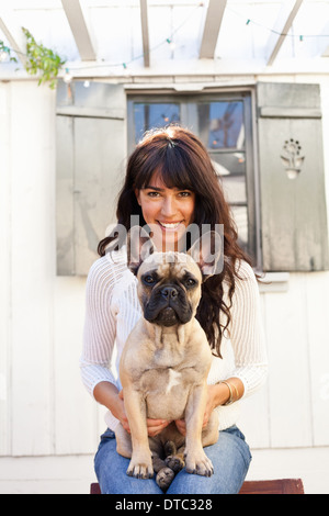 Porträt der jungen Frau Holding Hund Stockfoto