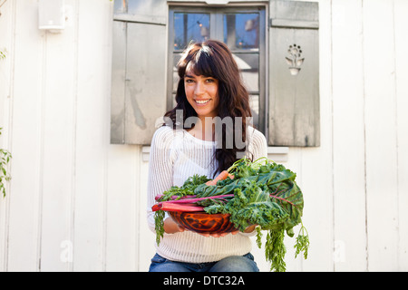 Porträt der jungen Frau hält einheimische Gemüse Stockfoto