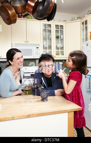 Älteres Paar und junge Tochter in Küche Stockfoto