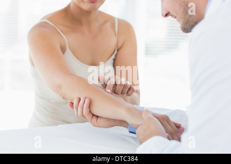 Männliche Physiotherapeuten untersuchen Hand Frau Stockfoto