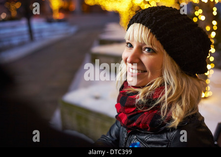 Junge Frau auf Stadtstraße mit Weihnachtslichter Stockfoto