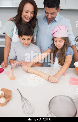 Familie von vier vorbereitenden Cookies in der Küche Stockfoto