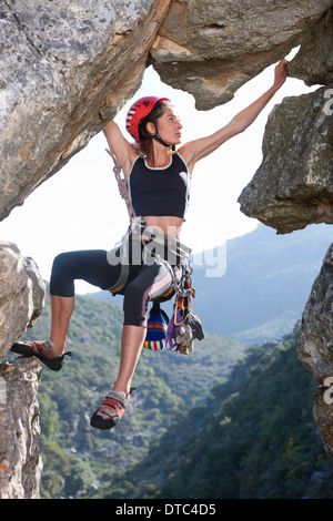 Junge weibliche Kletterer balancieren auf Felswand Stockfoto