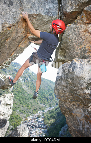 Junge männliche Kletterer balancing und halten Seil Stockfoto