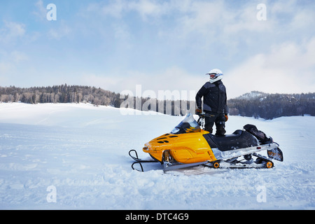 Mitte erwachsener Mann mit Motorschlitten, Togwotee Pass, Wyoming, USA Stockfoto