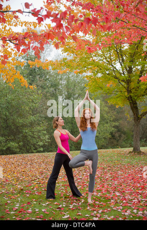 Yoga-Lehrer unterrichten junge Frau im Wald Stockfoto