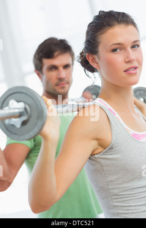 Junges Paar Aufhebung Hanteln im Fitnessstudio fit Stockfoto