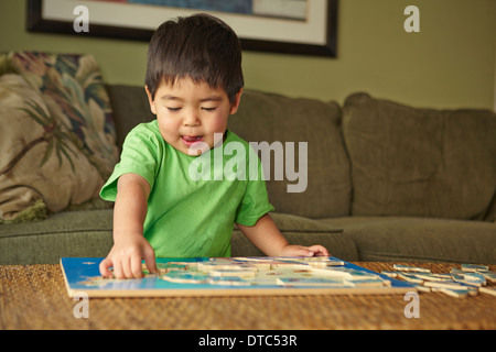 Jungen spielen Puzzle im Wohnzimmer Stockfoto