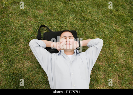 Geschäftsmann auf dem Rasen liegend Stockfoto