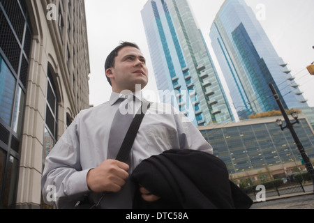 Geschäftsmann in Stadt umgeben von Wolkenkratzern Stockfoto