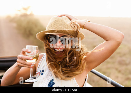 Junge Frau mit Hut hält Glas Wein Stockfoto