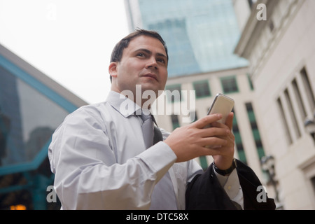 Geschäftsmann in Stadt umgeben von Wolkenkratzern Stockfoto