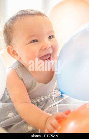 Babymädchen trägt Party-Kleid mit Ballon Stockfoto