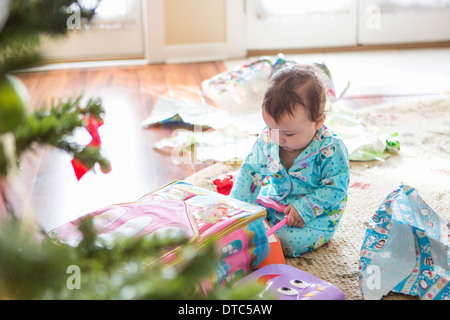 Babymädchen öffnen Weihnachtsgeschenke Stockfoto