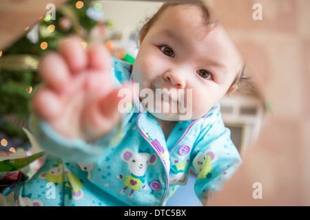 Babymädchen trägt Pyjama in Richtung Kamera erreichen Stockfoto