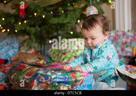 Babymädchen Eröffnung präsentiert ihr erstes Weihnachten Stockfoto