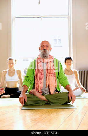 Reifer Mann in Lotus Pose im Yoga-Kurs Stockfoto
