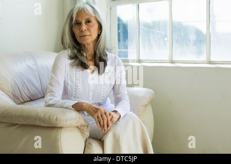Porträt von senior Frau sitzt in Wohnung Stockfoto