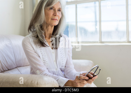 Porträt von attraktive ältere Frau sitzen in Wohnung Stockfoto