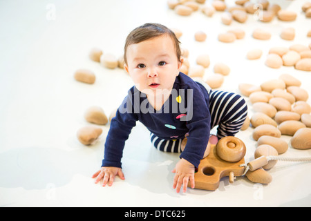 Babymädchen sitzen auf Boden mit Spielzeug Stockfoto
