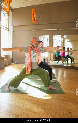 Leute, die Krieger posieren in Yoga-Kurs Stockfoto