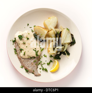 Gegrilltes Kalbsschnitzel mit einer cremigen Soße, gekochte Kartoffeln mit verwelkt Mangold, garniert mit frischen Kräutern Stockfoto