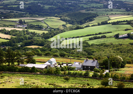 Blick auf grüne Felder und Landschaft, und Hütte mit kleiner Stromerzeugungswindmühle in der Nähe von Minions, Bodmin Moor, Cornwall, England Stockfoto