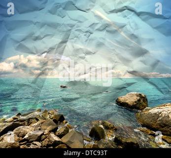 Steiniger Strand, klares Meer und blauen Wolkenhimmel auf eine Papierstruktur Stockfoto