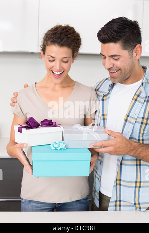 Überrascht Frau hält viele Geschenke von ihrem partner Stockfoto