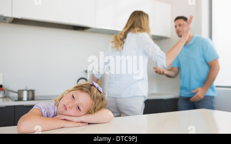 Gelangweilt Mädchen stützte sich auf den Tisch, während Eltern streiten Stockfoto