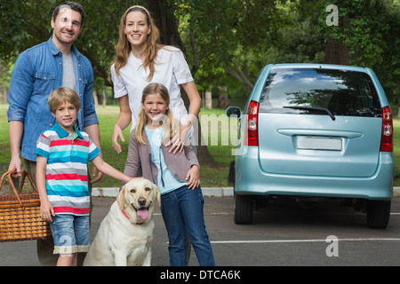 Glückliche Familie von vier mit Auto am Picknick Stockfoto