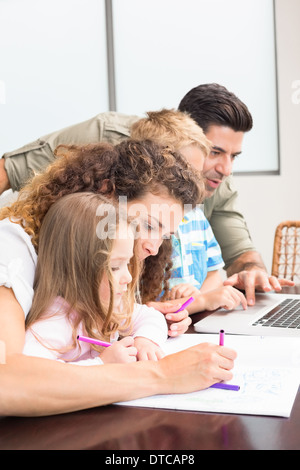 Attraktive Eltern Färbung und mit Laptop mit ihren Kindern Stockfoto