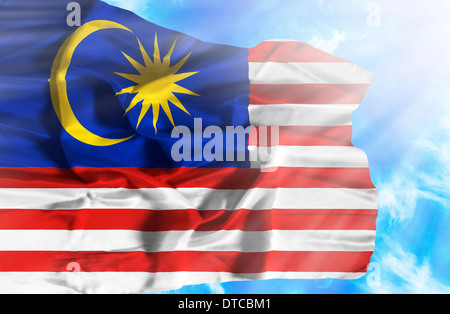 Malaysia wehende Flagge gegen blauen Himmel mit Sonnenstrahlen Stockfoto