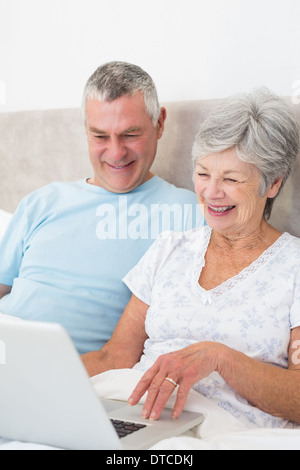 Älteres Paar mit Laptop-Computer im Bett Stockfoto