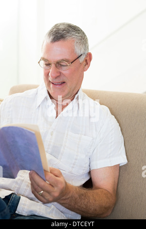 Senior Woman Buch zu Hause Stockfoto