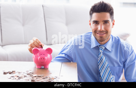 Fröhliche Geschäftsmann Sparschwein Münzen Inbetriebnahme Stockfoto