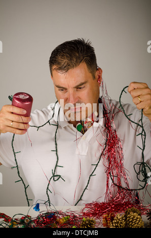 Kerl verwirrt zwischen einem Durcheinander von Party Dekoration Stockfoto