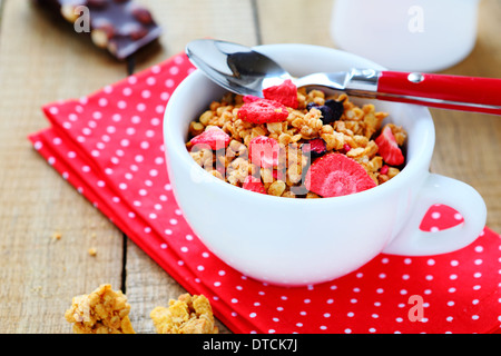 volle Tasse Müsli mit getrockneten Erdbeerscheiben, Essen Stockfoto