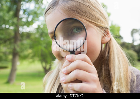 Junges Mädchen Blick durch die Lupe im park Stockfoto