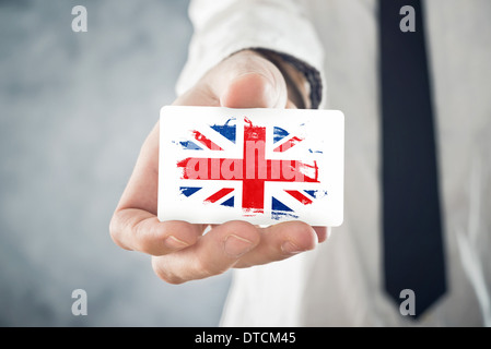 Britischer Unternehmer halten Visitenkarte mit Großbritannien Flagge. Internationale Zusammenarbeit, Investitionen, Geschäftsmöglichkeit Stockfoto