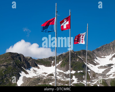 Fahnen der Schweizer Kantone Tessin (links), Wallis (rechts) und der Schweizerischen Eidgenossenschaft (Mitte) in der Schweizer Hütte fliegen Stockfoto