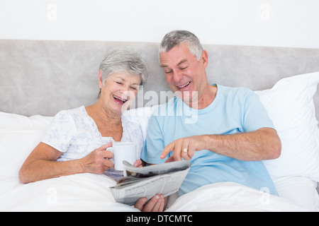 Älteres paar Zeitung im Bett lesen Stockfoto