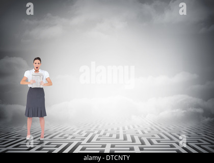 Zusammengesetztes Bild schockiert stilvolle Geschäftsfrau hält Zeitung Stockfoto