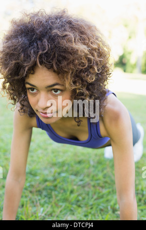 Engagierte Frau doing Push-ups im Park Stockfoto