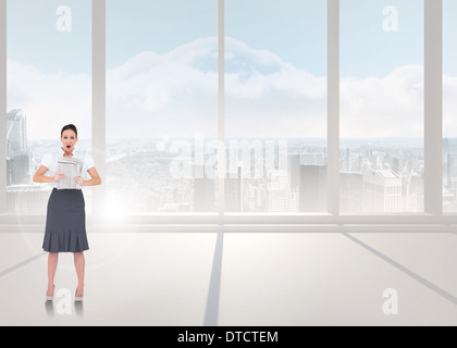 Zusammengesetztes Bild schockiert stilvolle Geschäftsfrau hält Zeitung Stockfoto